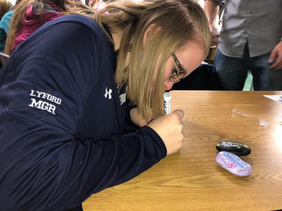 Kiara Lyford 18 paints rocks at NHS convention for Kindness Rocks Project