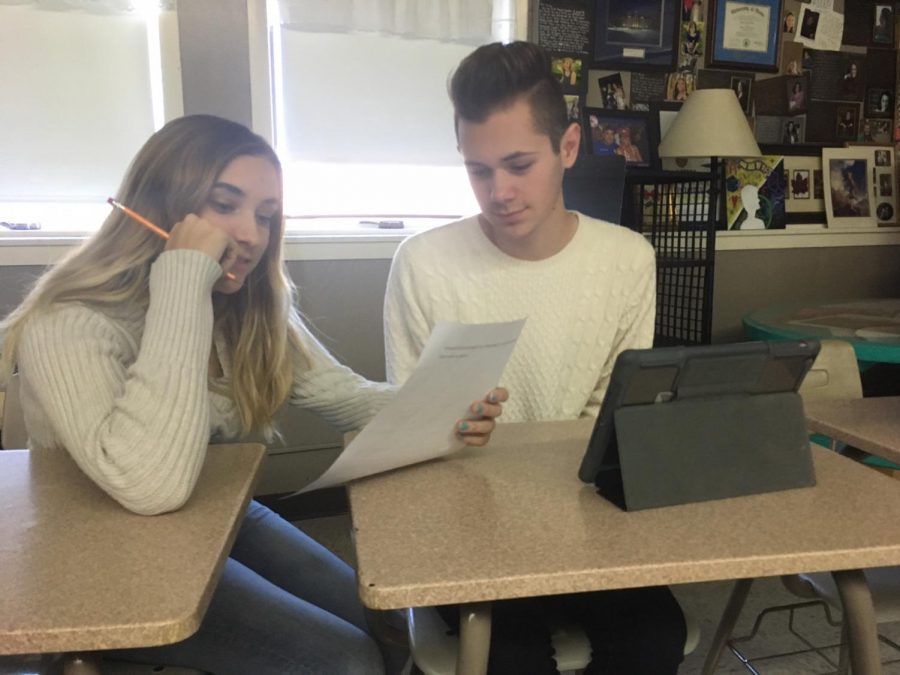 Taylor Fletcher 18 gives Andrew McArthur 20 editorial feedback for his news story on Deck the Halls.