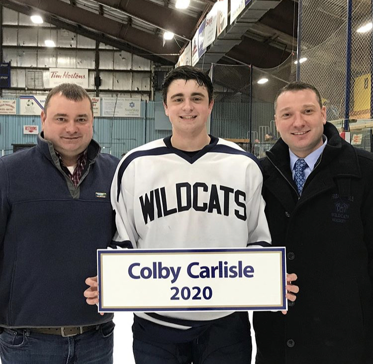 Junior Colby Carlisle poses with his father and uncle following his 100th point on January 25th at the Northern Maine Forum in Presque Isle