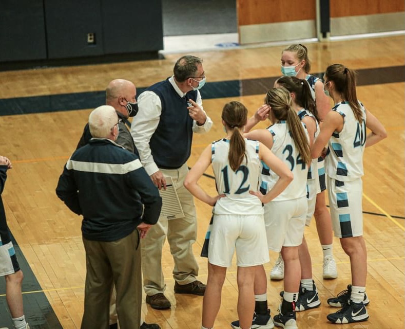 Head Coach Jeff Hudson speaks with his team during a timeout amid a February 2021 game at Presque Isle High School against Fort Kent