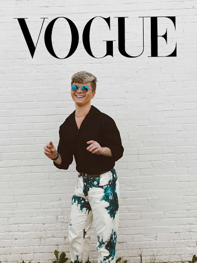 A fashionable young man stands in front of a white brick wall. He is wearing sunglasses, a black V-necked shirt, and bleached pants. The photo is in full color, and above him spells VOGUE like the fashion magazine.