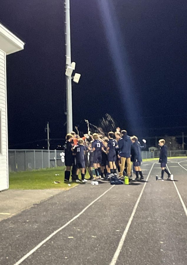 Boys varsity soccer team celebrates after win against MDI in the quarterfinal game on October 26.