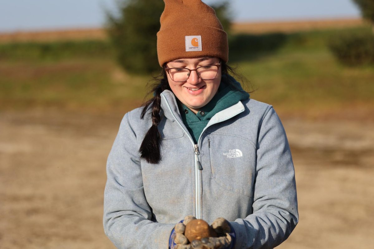 Olivia Goodine ‘25 inspects a potato at Irving Farms.