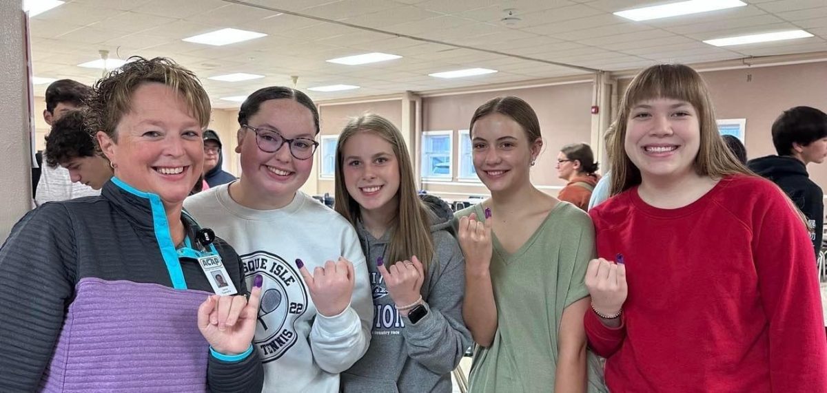 Raise+your+pinkies.+The+Rotary+Club+visits+Presque+Isle+high+school+on+October+24.+Every+World+Polio+Day%2C+high+school+students+donate+to+help+eradicate+polio.+Juniors+Bobbi+Guerrette%2C+Bailey+Davenport%2C+Hannah+Ousby+and+Carlee+Wood+show+off+their+purple+pinkies+with+Rotarian+Jamie+Guerrette.%0A
