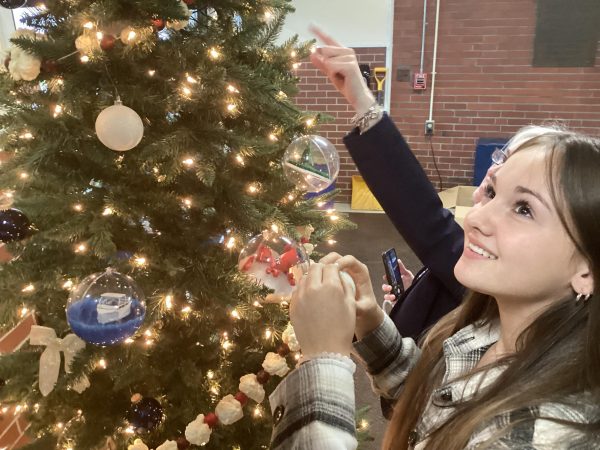 Astra Laughton ‘26 and Mrs. Whitten-Smith put ornaments on the tree in the lobby during period 7.